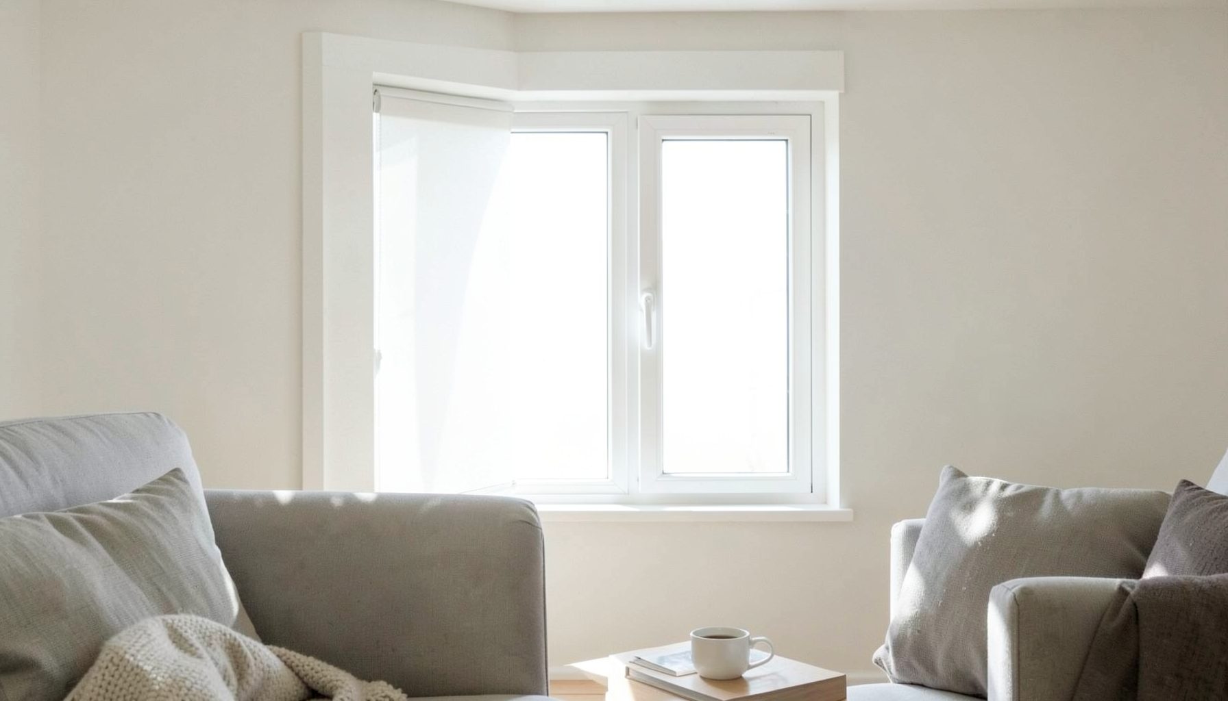 Bright white UPVC window installed in a living room wall, natural light streaming through, clean modern look
